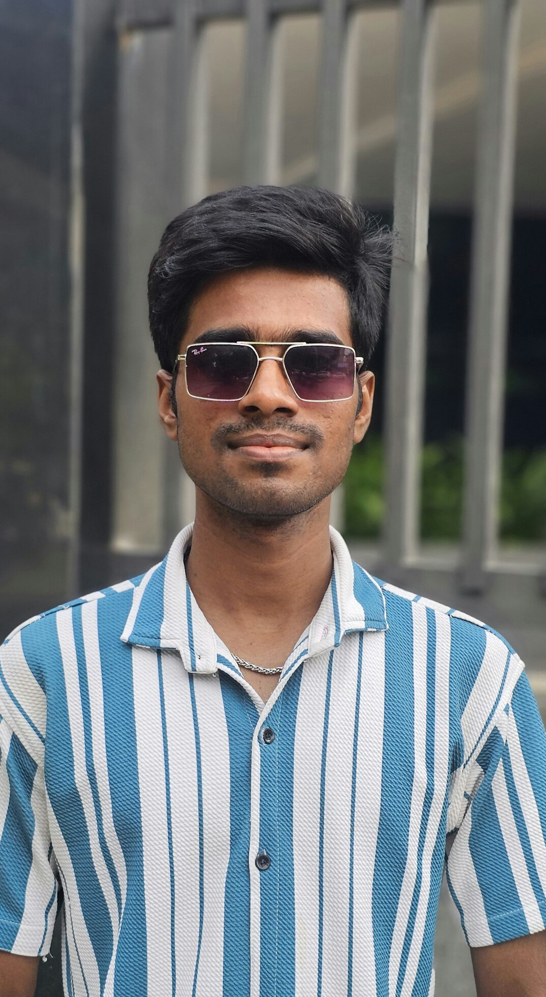 Portrait of a man with short beard and glasses in a casual shirt